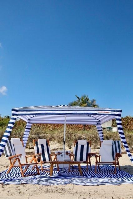 Beach setup with striped cabana on sand